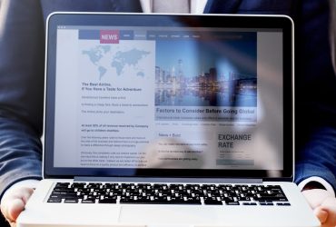 A businessman presenting news on a laptop