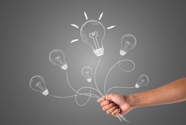 A hand that holds many ideas written with white chalk, draw concept.